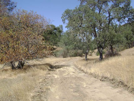Further up Pacheco Creek Trail, a grader parked alongside the trail bakes in the hot sun, with nobody inside.