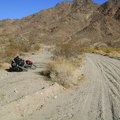 I try riding the worn-out paved track along the wash to avoid the deep sand and gravel in Jackass Canyon