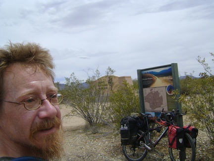 The bottom of Cima Road exits Mojave National Preserve; I take a break by the monument that folks see upon entering the Preserve